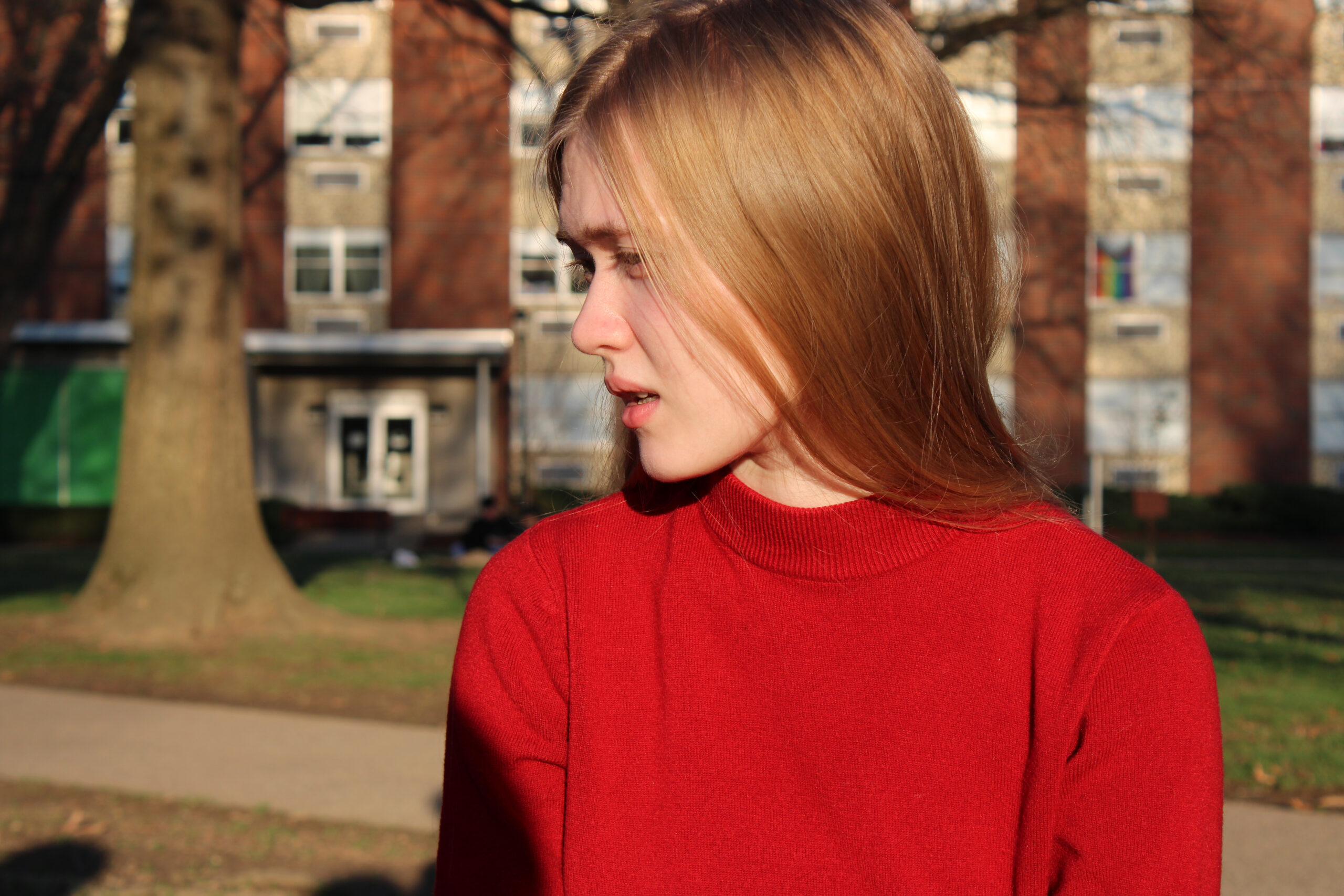 blonde girl turned to the side in red sweater